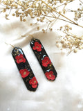 Boucles pendantes noires fleurs rouges